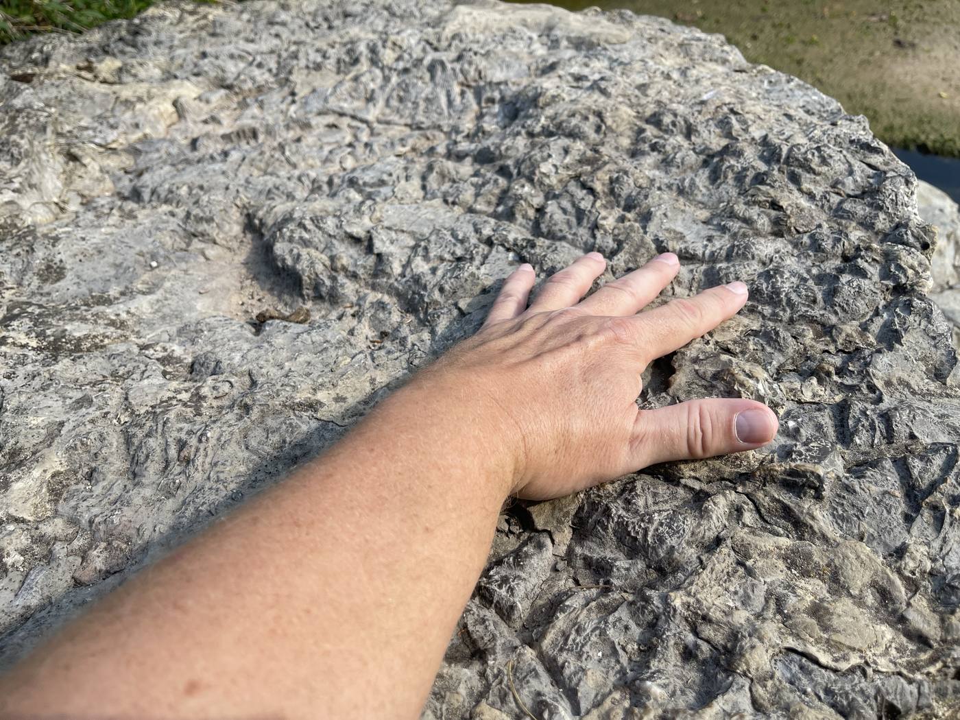 Eine Hand liegt auf warmem Stein